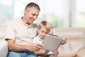 Child shows father how to connect to WiFi. Herschel Systems Limited